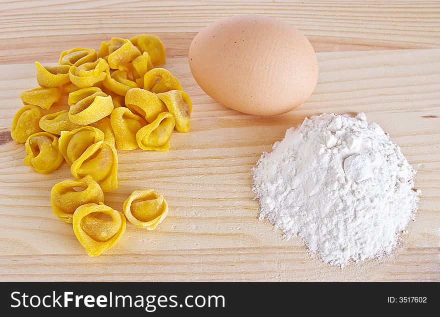 Italian tortellini made in Bologna upon a wood layer with egg and flour