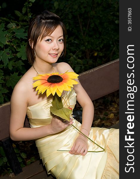 A girl holding a sunflower in woods. A girl holding a sunflower in woods