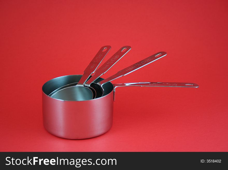 Measuring cups fanned out on red background