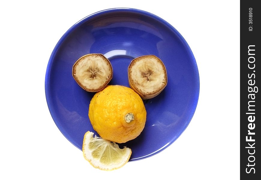 Funny face made of lemon and banana on a blue plate. Funny face made of lemon and banana on a blue plate