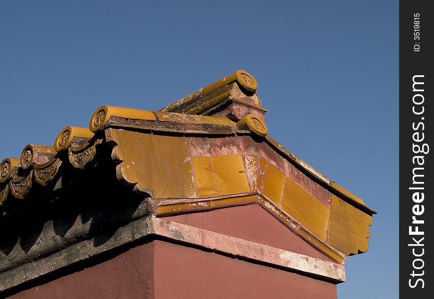 Edge of a chinese temple roof build from yellow tiles. Edge of a chinese temple roof build from yellow tiles