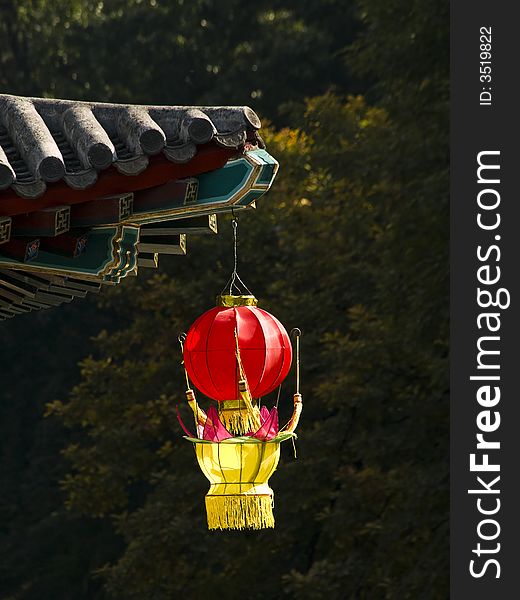 Red and yellow lantern hanging at the edge of a chinese temple roof. Red and yellow lantern hanging at the edge of a chinese temple roof