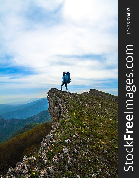 Sporty woman with backpack on top of the rock. Sporty woman with backpack on top of the rock