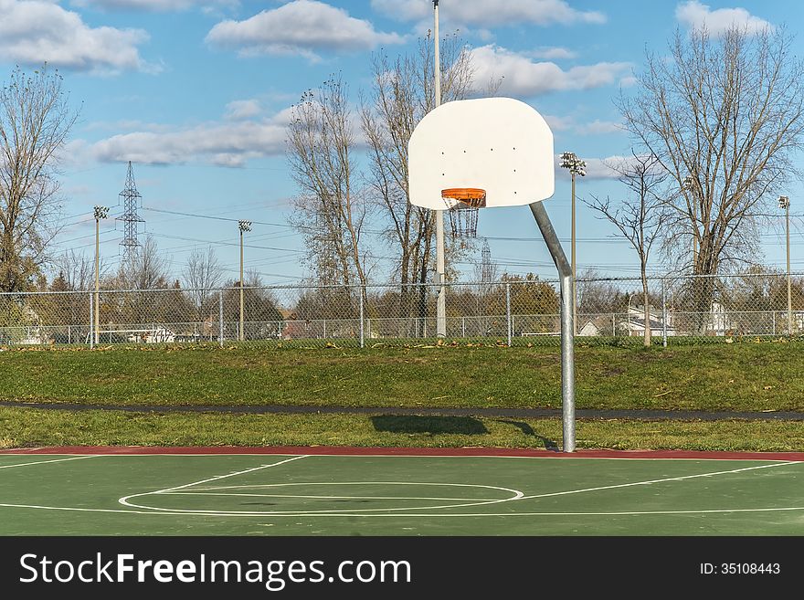 Basketball hoop in a green park with a blue sky horisontal. Basketball hoop in a green park with a blue sky horisontal