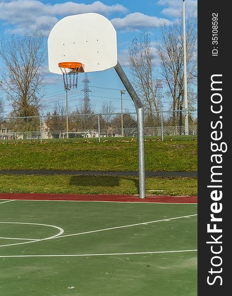 Basketball hoop in a green park with a blue sky. Basketball hoop in a green park with a blue sky