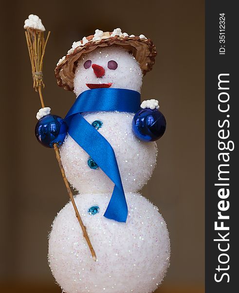 Closeup of toy snowman wearing a straw hat and scarf, holding broom. Closeup of toy snowman wearing a straw hat and scarf, holding broom