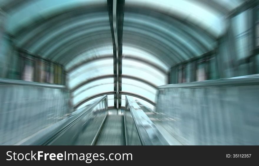 Videography is made from the steps of a moving escalator under the glass roof. Zoom Blur. Videography is made from the steps of a moving escalator under the glass roof. Zoom Blur