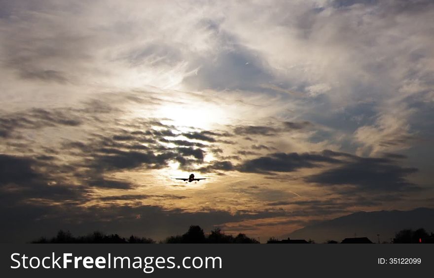 Jet airplane landing in sunset sky