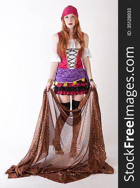 An image of a pretty young woman in a pirate costume, holding up metallic fabric. An image of a pretty young woman in a pirate costume, holding up metallic fabric