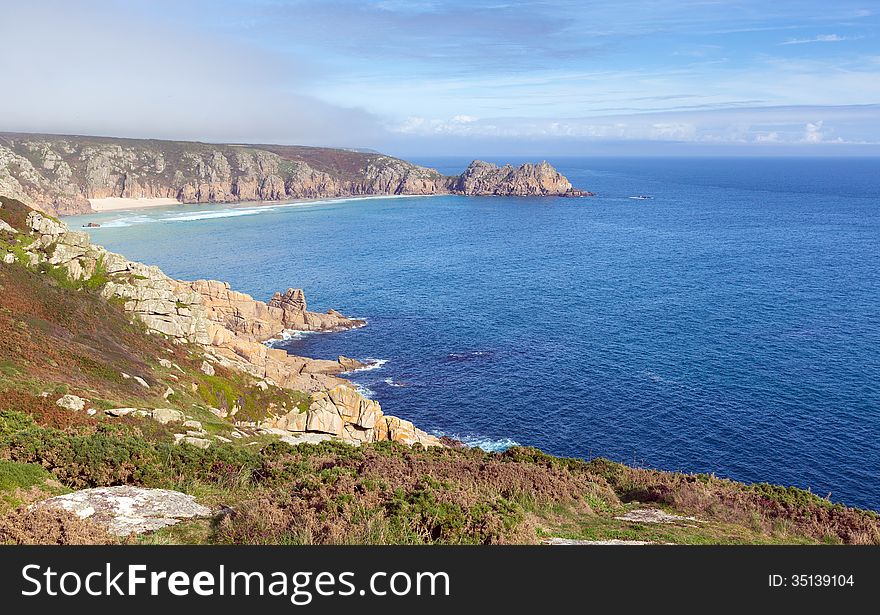 Coast of Cornwall England in autumn with mist and blue sky near the Minack Theatre and Porthcurno