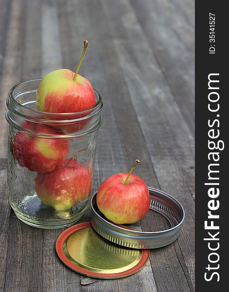 Crabapples in a Sealer Jar on a wooden plank.