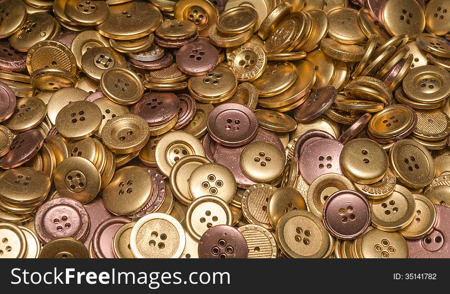 Many Gold and Brone coloured buttons. Many Gold and Brone coloured buttons
