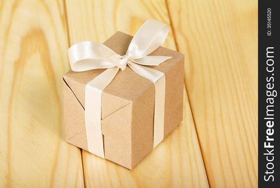 Gift box from a kraft paper against a wooden table