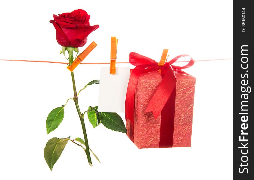 The rose, card and gift hang on rope isolated on white