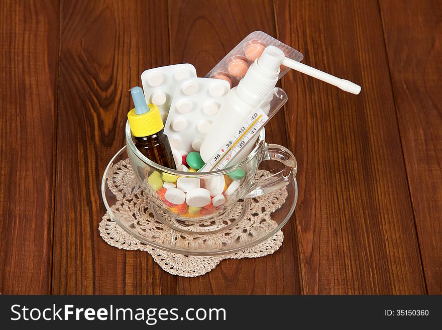 Cup with different medicines on wooden a table