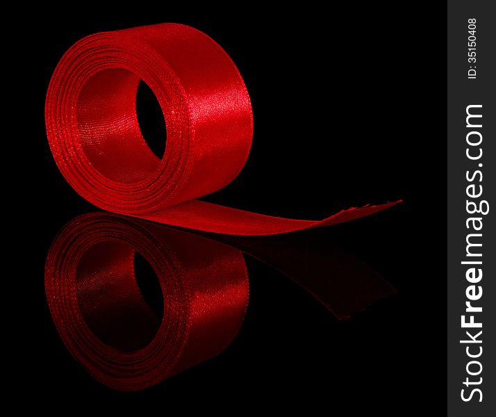 Hank of a red satin ribbon isolated on the black