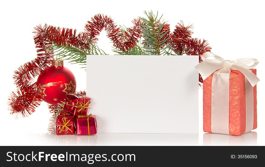 Christmas gifts, fir-tree branch decorated by toys and tinsel, the empty card for the letter isolated on white