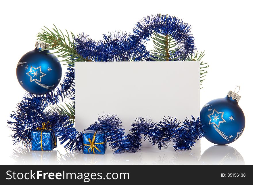 Fir-tree branch with tinsel, small gift boxes, two Christmas toy and a card isolated on white