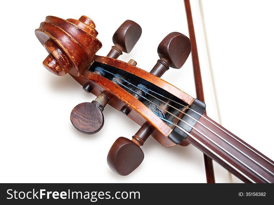 Pegbox of old threadbare antique cello with bow isolated over white background with shadow. Pegbox of old threadbare antique cello with bow isolated over white background with shadow