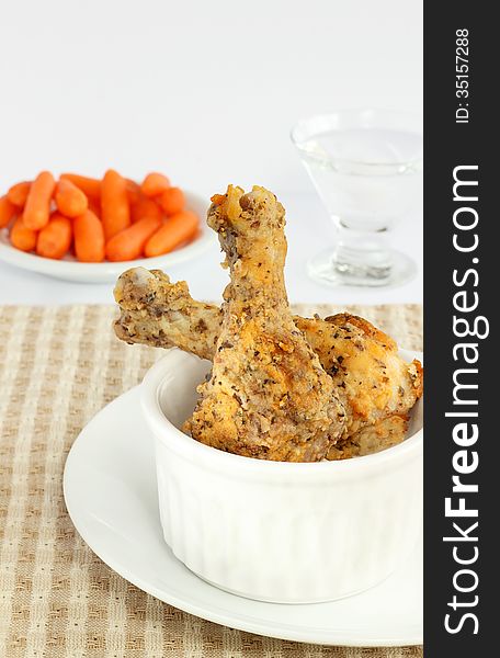 Drumsticks coated with panko crumbs and seasoning baked in the oven served with raw baby carrots. Drumsticks coated with panko crumbs and seasoning baked in the oven served with raw baby carrots