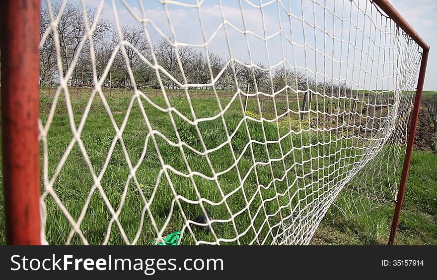 Soccer ball flies into old goal hitting net,nature