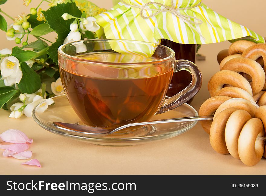 Jam, tea, bagels, closeup on a beige background. Jam, tea, bagels, closeup on a beige background