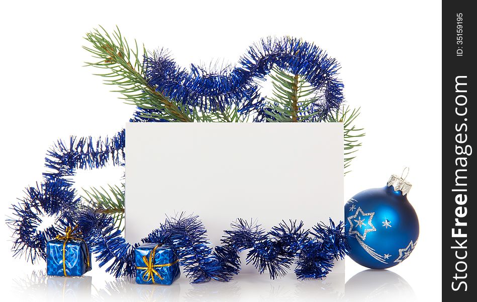 Fir-tree branch with tinsel, small gift boxes, a Christmas toy and a card isolated on white. Fir-tree branch with tinsel, small gift boxes, a Christmas toy and a card isolated on white