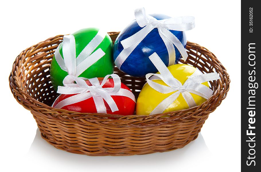 Wattled basket with the Easter eggs, isolated on white