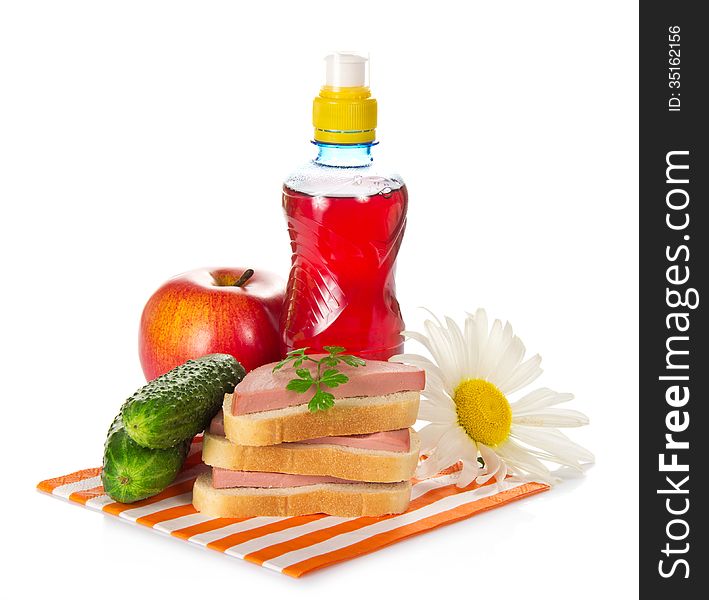 Sandwiches, cucumbers, red apple, camomile and bottle with compote, on a striped napkin, isolated on white