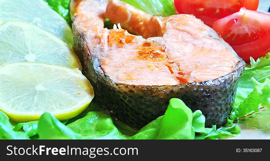 Grilled trout with tomato, lemon, lettuce. Grilled trout with tomato, lemon, lettuce