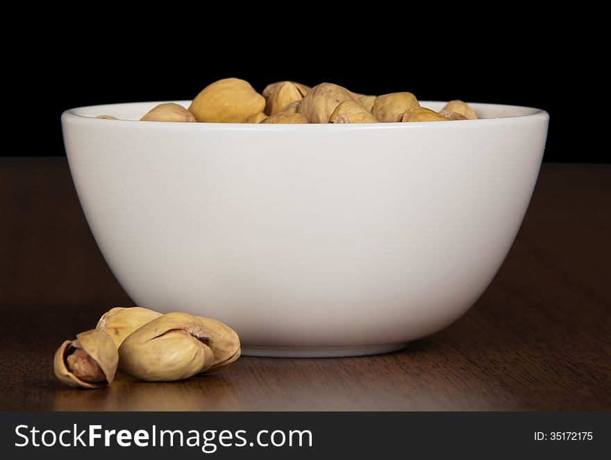 Dry salted pistachio fruit in bowl on the table. Dry salted pistachio fruit in bowl on the table.