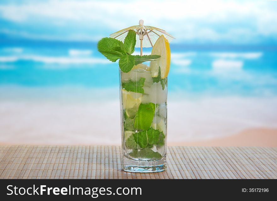 Mojito cocktail on a bamboo cloth, against the sea