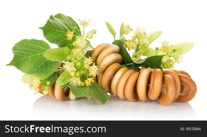 The bagels connected by a rope, and linden flowers, isolated on white