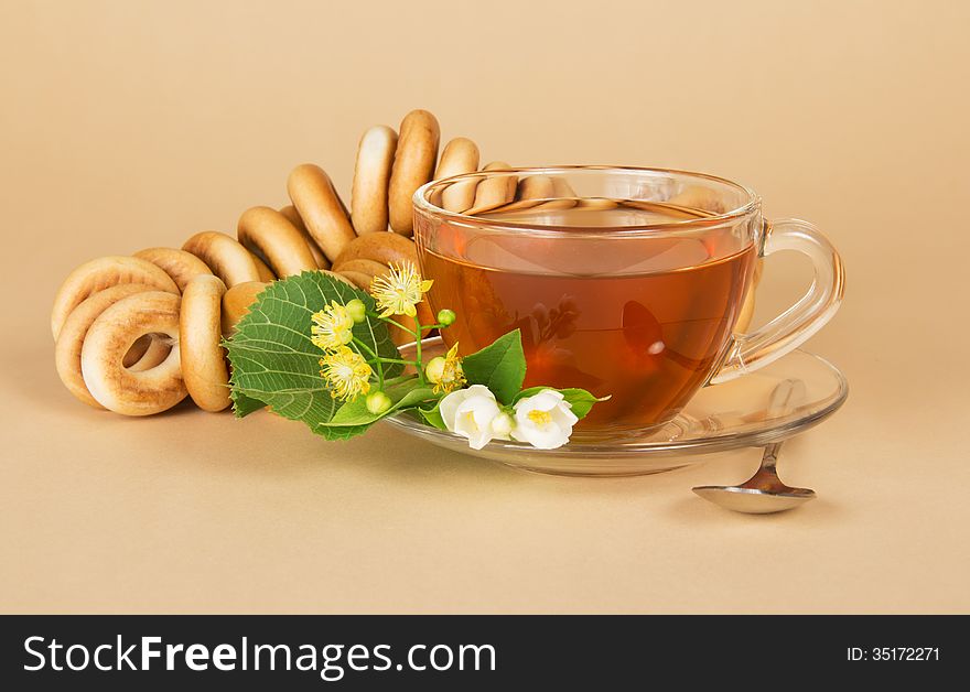 Cup of tea, bagels, linden and jasmine flowers, on a beige background