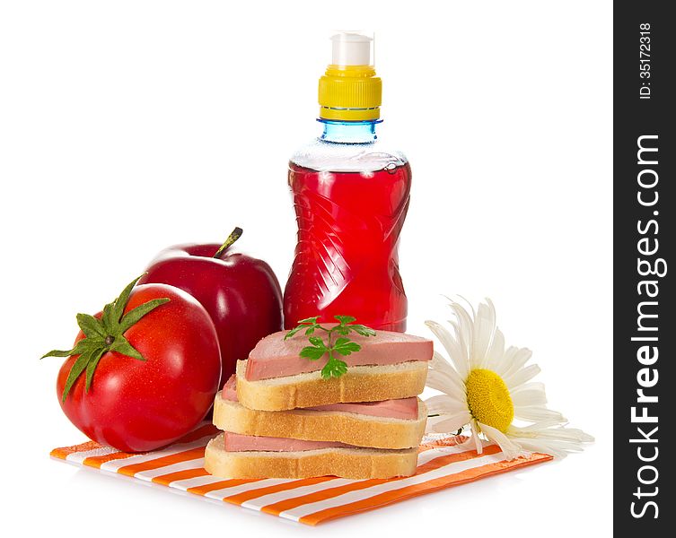 Sandwiches, tomato, red apple, camomile and bottle with compote, on a striped napkin, isolated on white. Sandwiches, tomato, red apple, camomile and bottle with compote, on a striped napkin, isolated on white