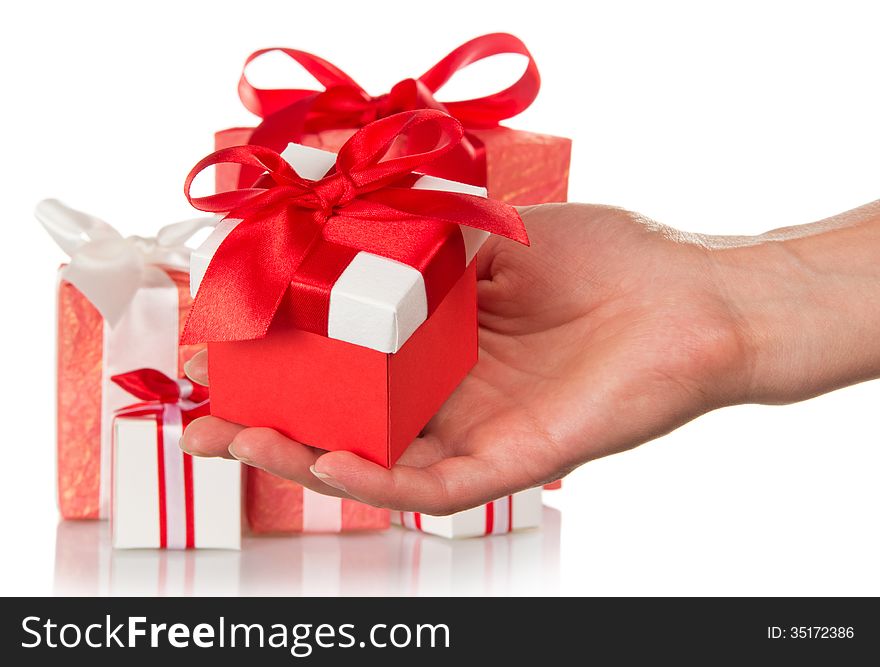 A lot of gift boxes and woman's hand holding a gift isolated on white