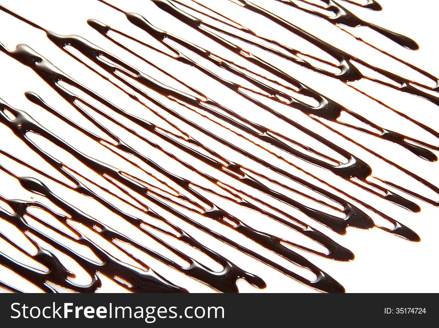 The thin streams of the melted chocolate isolated on white. The thin streams of the melted chocolate isolated on white
