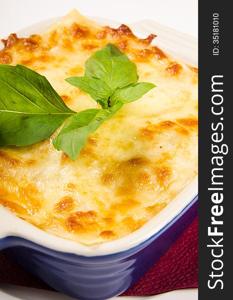Lasagna in a blue plate with basil