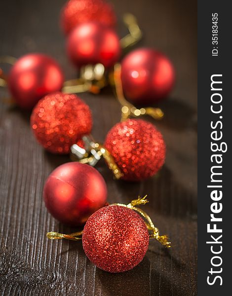 Small red Christmas balls on a wooden table