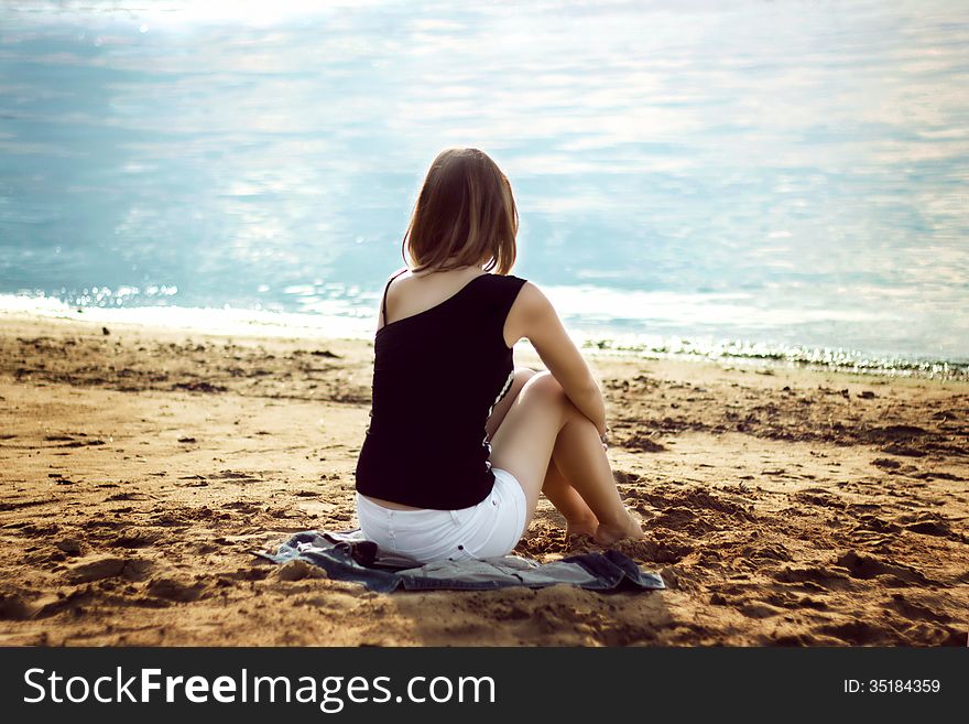 Lonely girl relaxing on the sea beach