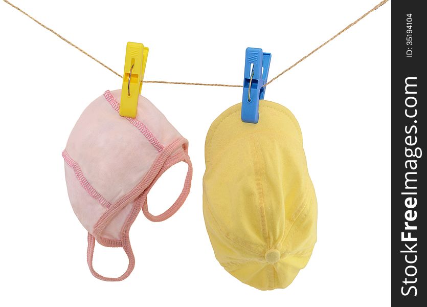 Pink and yellow caps hanging on rope isolated. Pink and yellow caps hanging on rope isolated
