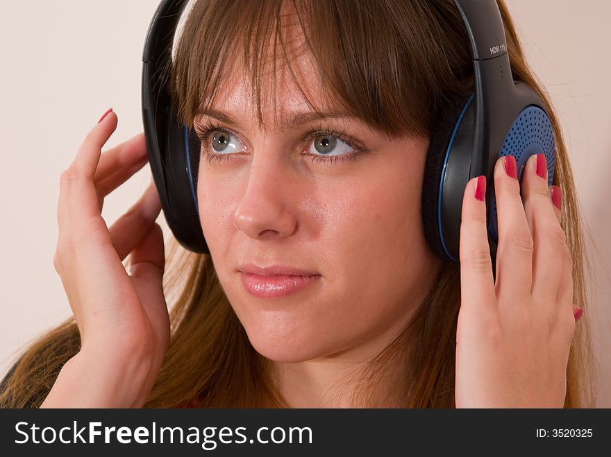 A girl, wearing headphones, listening to some music. A girl, wearing headphones, listening to some music