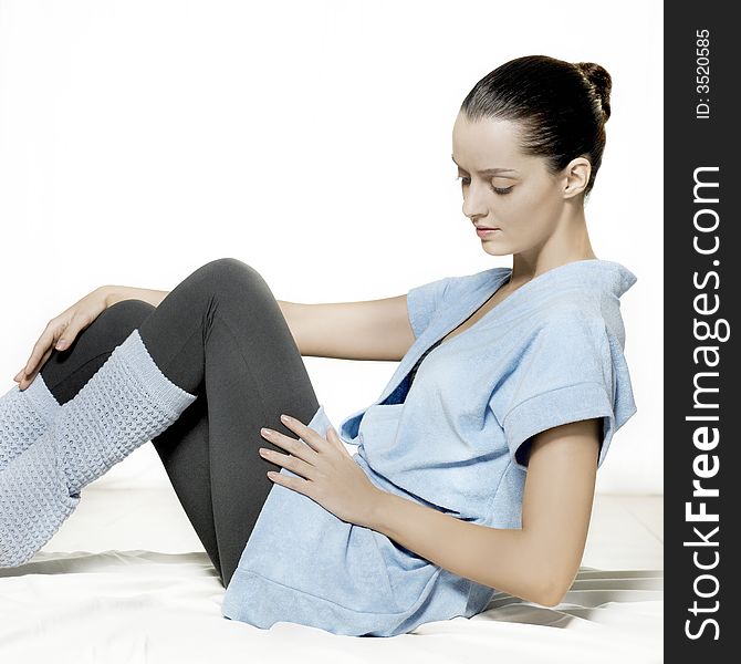 Side face of a young woman in bath robe sitting on bed. Side face of a young woman in bath robe sitting on bed