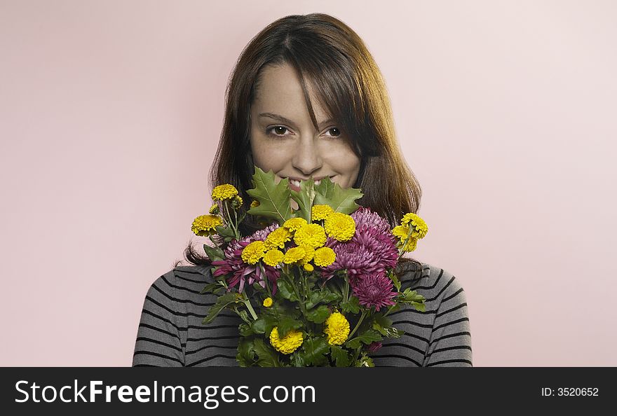 Woman smiling through a bunch of flowers. Woman smiling through a bunch of flowers
