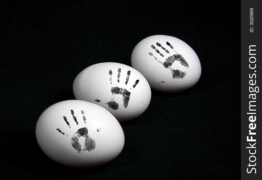 Three whole eggs with smudged hand prints on the shell. Three whole eggs with smudged hand prints on the shell.