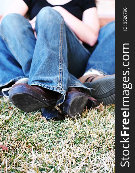 Three quarter length shot of heterosexual couple sitting down on grass together