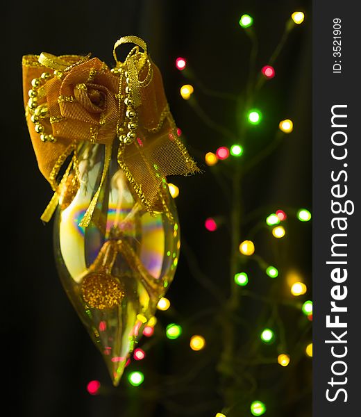 A refractive pointed ellipsoid ornamented with a fabric rose hung in mid air against a blur background of colored lights. A refractive pointed ellipsoid ornamented with a fabric rose hung in mid air against a blur background of colored lights.