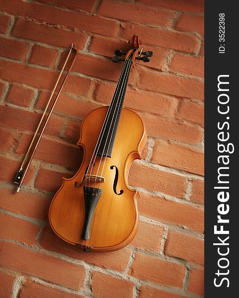 Violin & bow over red brick wall