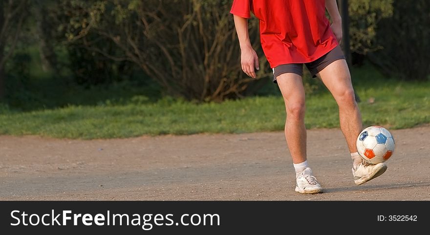 A football player's legs skilfully juggling with a ball. A lot of copy space on the left.