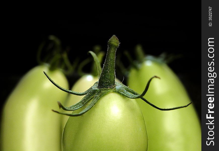Group of thre green tomatoes close up on black background. Group of thre green tomatoes close up on black background